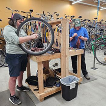 Two people working on bikes at bike shop