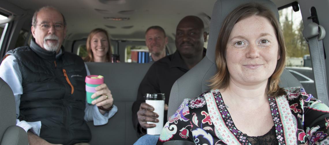 Five people with coffee in a vanpool
