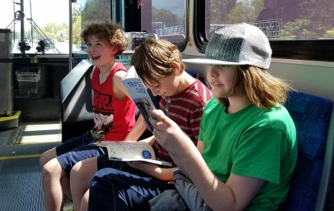 Three pre-teens riding the bus